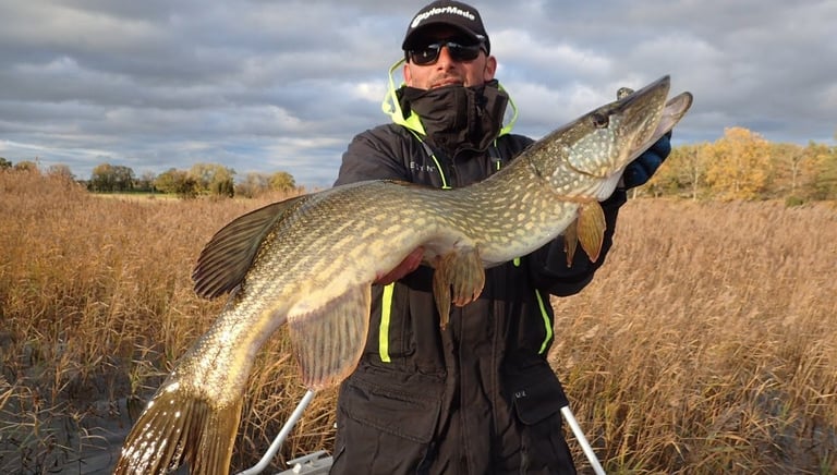 a angler holding a large pike in sweden