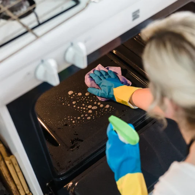 A woman deep cleaning the interior oven in a residential home