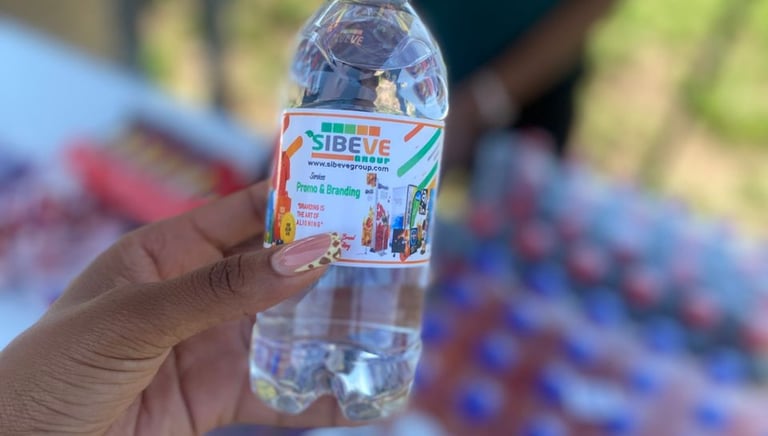 a person holding a sibeve branded bottle of water in front of a table