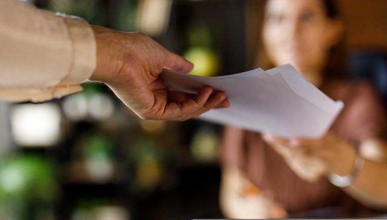 Steady hand passing a draft across the table representing cooperative editing