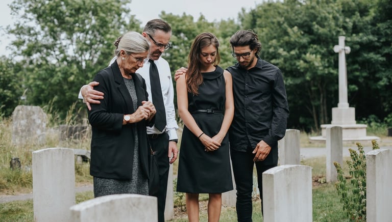 Family standing together at a cemetery, remembering a loved one with grace