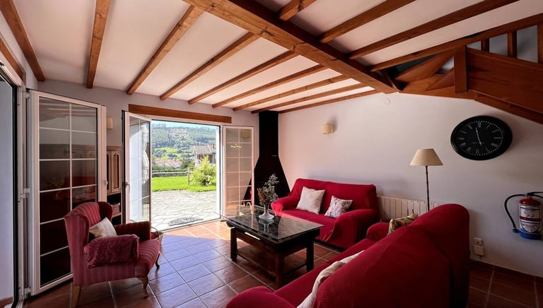 Sala de estar de la casa Mar con dos sofás, televisión y chiemenea