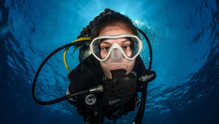 a woman in a scuba suit and goggles in the water