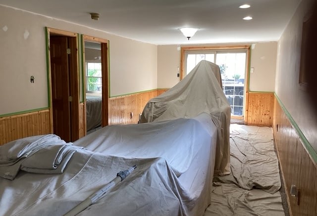 a room with drop clothes covering furinture