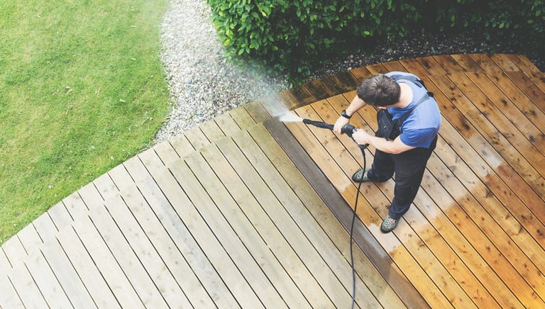 a man is using a pressurer washer to clean a deck
