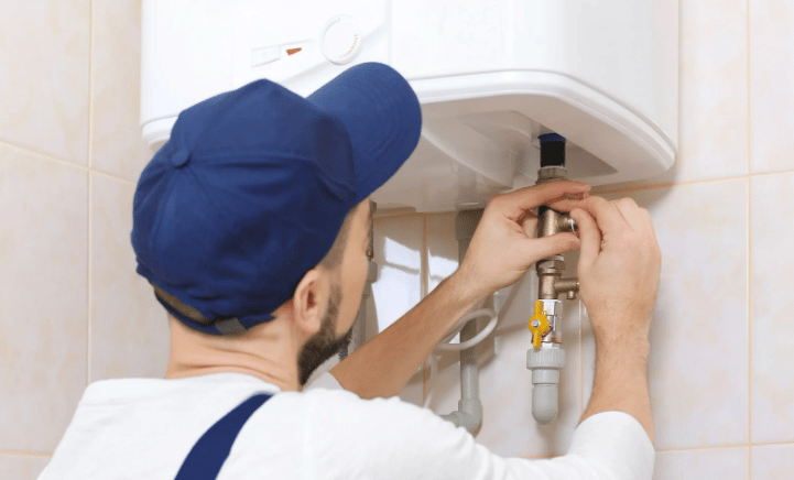 A plumber installing a water heater in a bathroom