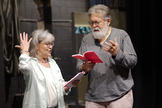 a man and woman standing in front of a stage