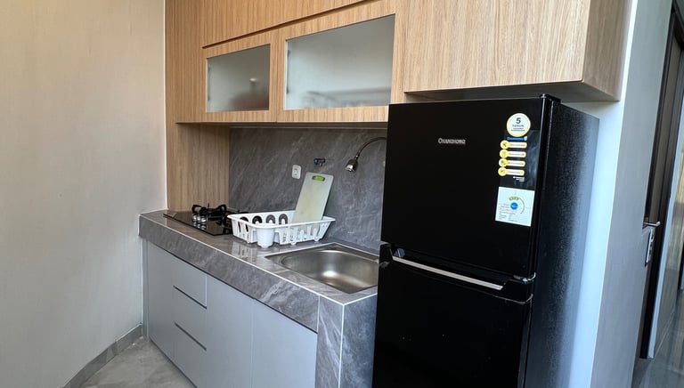 Dapur dan fasilitas umum di Kos Si Bos Surabaya dengan kulkas, wastafel, dan area bersih