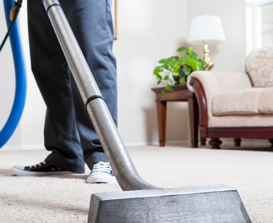 a man is cleaning a carpet with an extractor wand