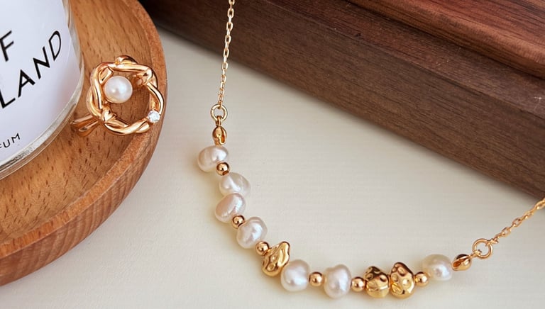 eine rosa Rose und ein Glas mit natürlichem Perlenschmuck auf einem Tisch