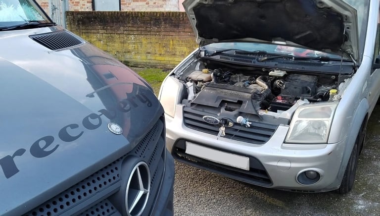 a van with bonnet up having engine diagnosed