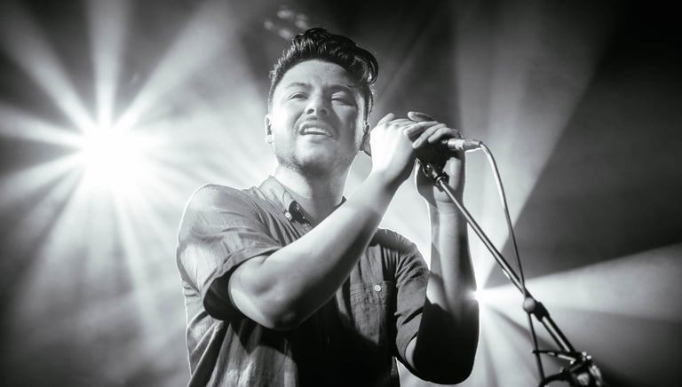 a man in a shirt is holding a microphone