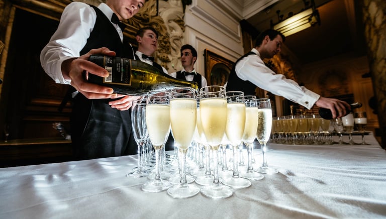 a waiter is pouring champagne into glasses of champagne