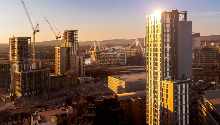 a city skyline with a sun setting in the background