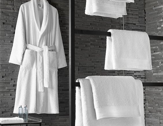 a bathroom with towels and robe on a towel