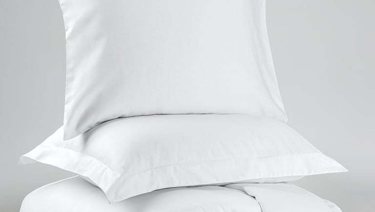 a stack of pillows and pillows on a bed