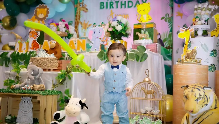 a young boy standing in front of a birthday party
