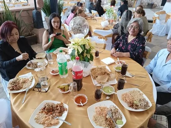 Invitados disfrutando carnitas en servicio de catering para evento familiar en Querétaro.