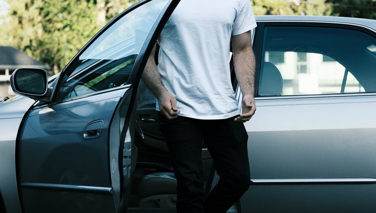Commercial video production services: man standing in front of a car wearing a tie-dye shirt