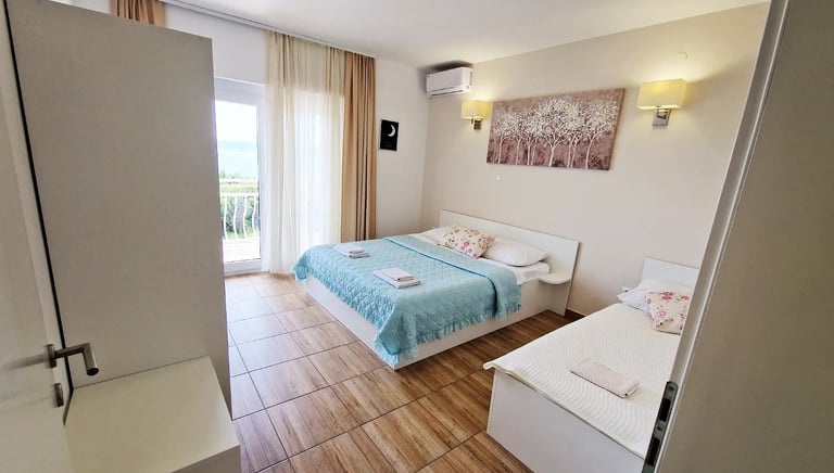 room with a two beds, cabinet and windows