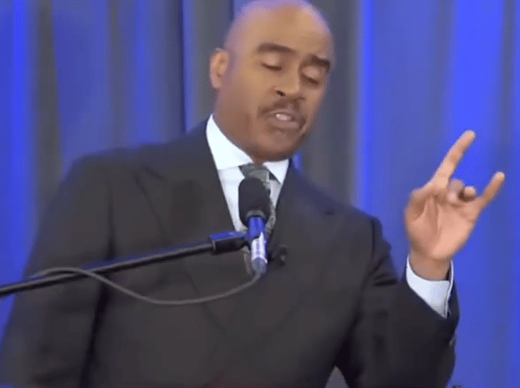 Gino Jennings of Truth of God Broadcast showing hand signs at the FCOOLJC on March 23 2024