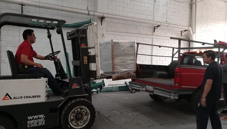 hombre en montacargas llevando transformador a camioneta rija