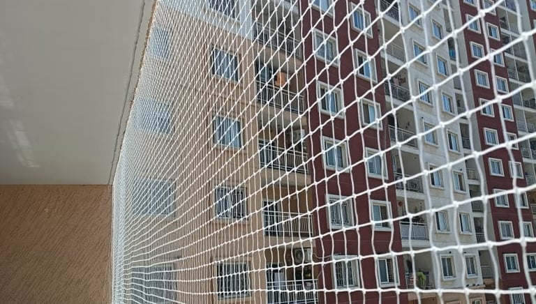 Wide shot of a building facade covered with pigeon nets, showing neat and professional installation.