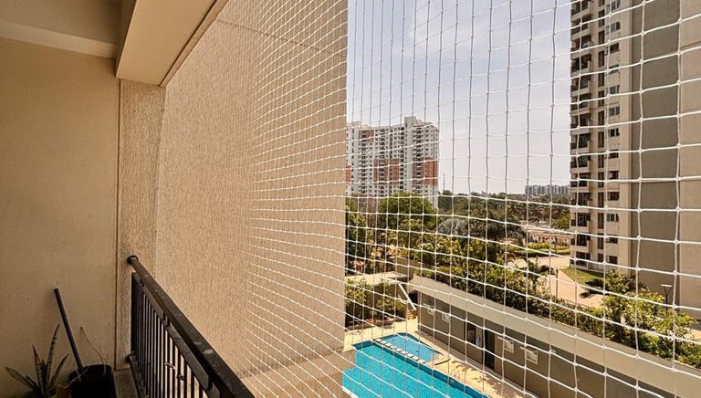 A close-up of a sturdy pigeon net installed on a sunny balcony in Anna Nagar.