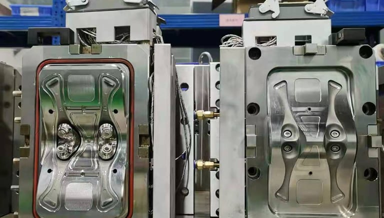 Precision plastic injection mold tool for industrial manufacturing sitting on a warehouse workbench.