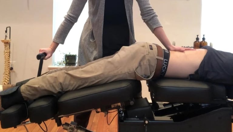 Kiropraktor på arbeidsplassen justerer ryggen til pasient som ligger på behandlingsbord
