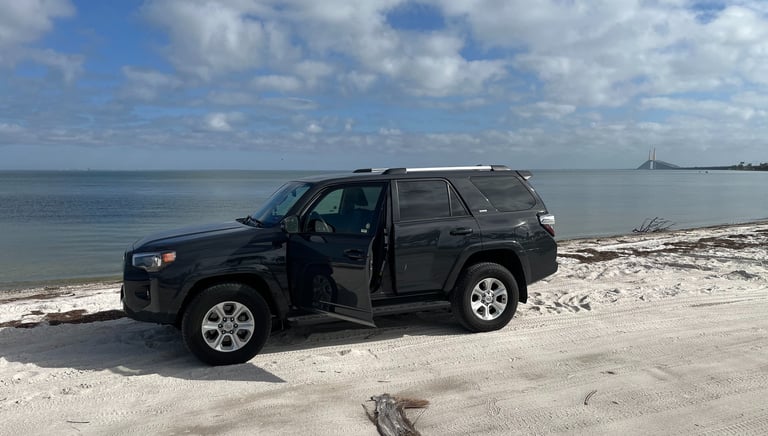 a black suv parked on a sandy beach