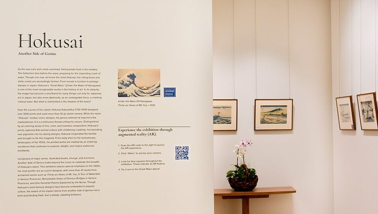 Exhibition installation image of Hokusai: Another Side of Genius that shows the wall text and prints