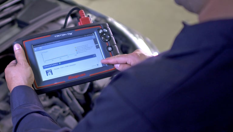 Qualified mobile mechanic performing car diagnostics with state-of-the-art equipment