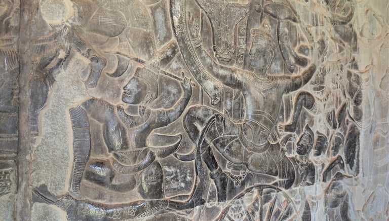 carved warriors on a large stone wall panel at Angkor Wat, Cambodia