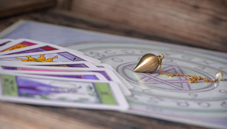 Cartes de tarot et pendule utilisés en radiesthésie et guidance spirituelle