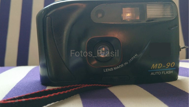 Sobre uma almofada está a majestosa, uma câmera fotográfica de filme do final dos anos 90