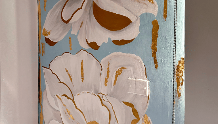 Mural pintado con colores suaves y dorado sobre pared decorativa en el hogar.