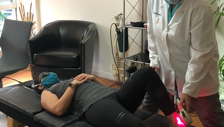 Dr. Lonna Denny utilizing cutting-edge technology like cold laser therapy to a patient.