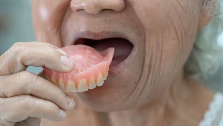 foto idosa colocando dentadura na boca