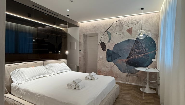 a bedroom with a bed and a large painting on the wall