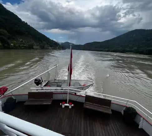 Scenic view from the back of a boat cruising the Danube River through the Austrian Alps.