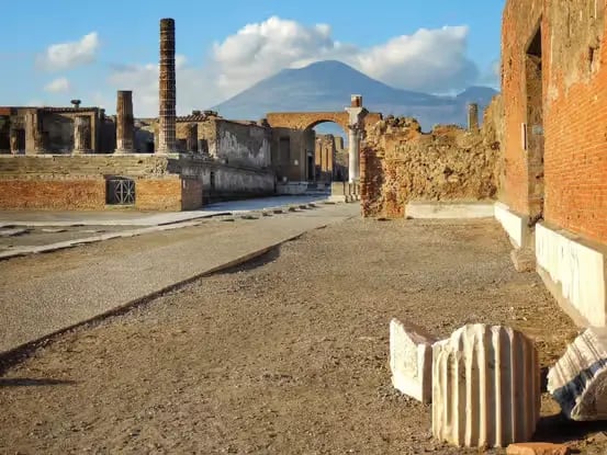 Pompeii ancient forum street with Mount Vesuvius volcano in the background, Italy