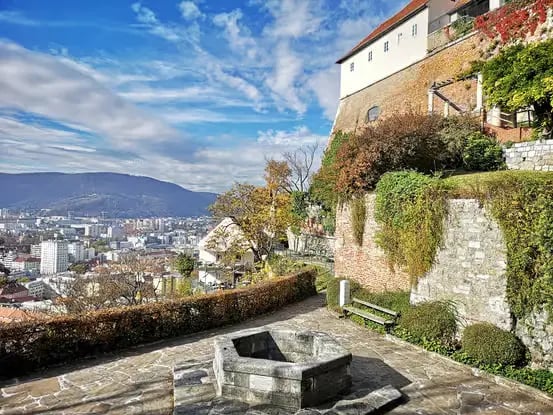 Panoramic view of Graz city from Schlossberg hill with ivy-covered stone walls