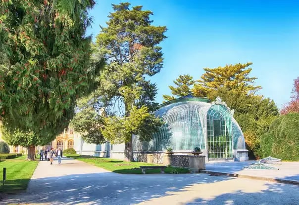 The historic 19th-century cast-iron greenhouse (Palm House) in the gardens of Lednice Chateau, South Moravia.