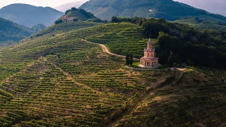 Historic church nestled among terraced Prosecco vineyards in Conegliano Valdobbiadene hills