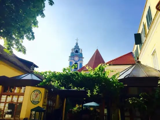 Charming Dürnstein street with vine-covered buildings and iconic blue church tower