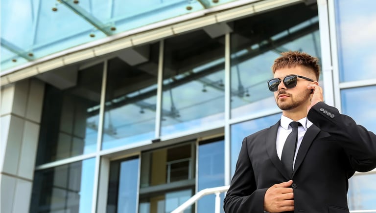 Force Prévention Sécurité – Agent de sécurité en costume noir, équipé d'oreillettes et de lunettes de soleil, assurant la sur