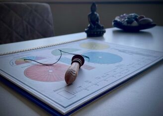 Um pendulo de madeira repousado sobre graficos