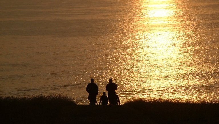 Walkers silhouetted strolling down to the pub