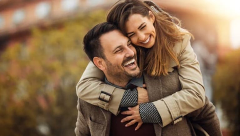 a man and woman are smiling and hugging martin pe coach de parejas